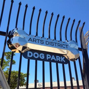 Fence at the Arts District Dog Park with chrome dog park signage.